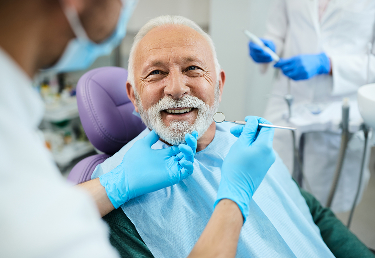 Smiling senior patient in dental chair during checkup